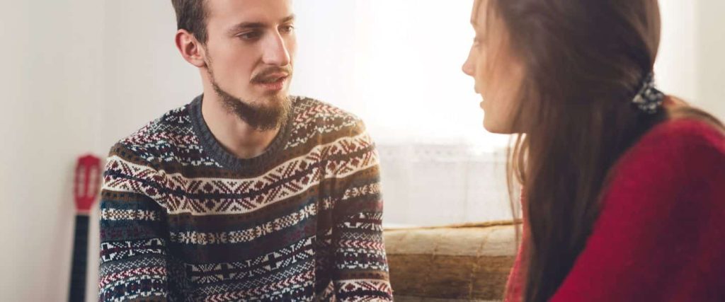 Pareja mirándose a los ojos y escuchándose atentamente, mostrando interés y conexión.